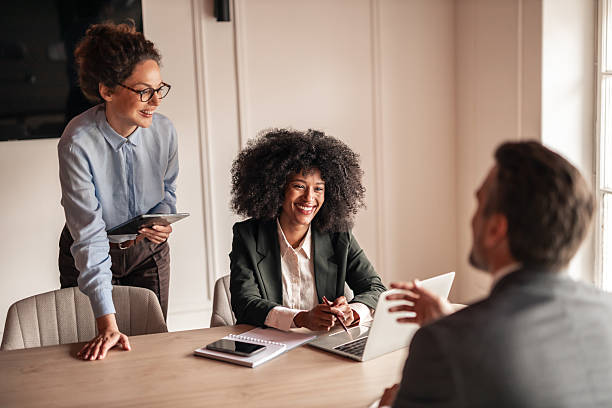 istock Friendly Business Meeting with Smiling Professionals Collaborating in Sunlit Office 2233322856