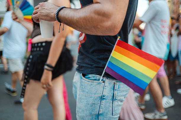 istock Young man showing rainbow flag at pride parade 2233325174