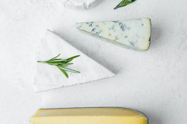 istock Selection of assorted cheeses with herbs on a white surface 2233325504