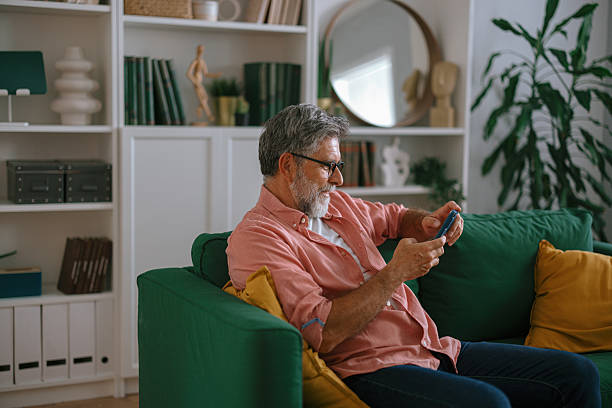 istock Senior man using phone and relaxing at home. 2233326805
