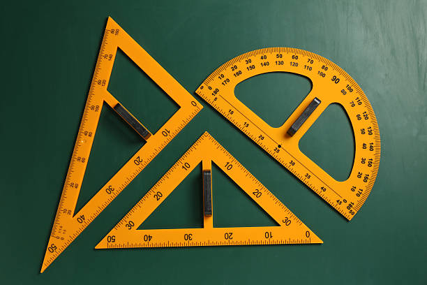 istock Protractor and triangle rulers on green chalkboard, flat lay 2233326982
