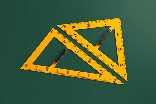 istock Triangle rulers on green chalkboard, top view 2233327029