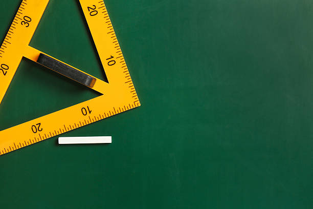 istock Triangle ruler and chalk on green chalkboard, top view. Space for text 2233327112