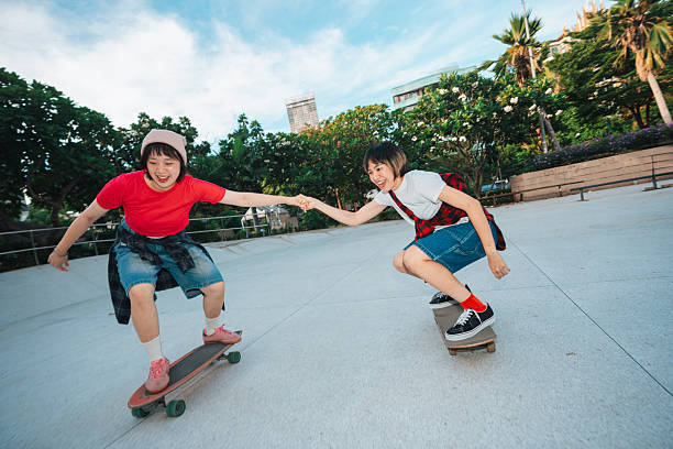 Asian girls skateboarder practicing in the public park on weekend.