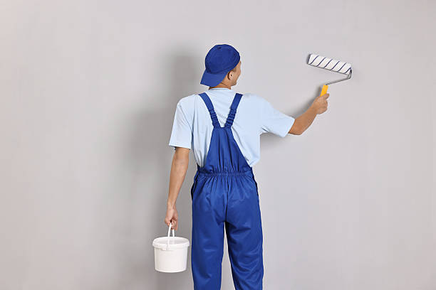 istock Male handyman painting wall with roller indoors, back view 2233328842