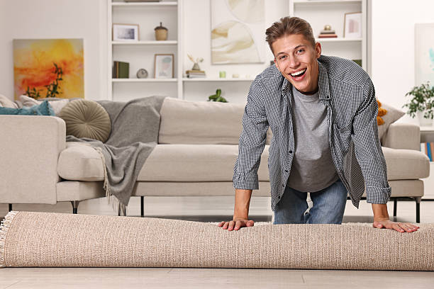 istock Happy decorator rolling out beige carpet indoors 2233328882