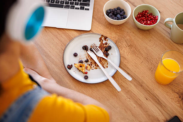 istock Female freelancer finishing up her breakfast while working from home 2233335781