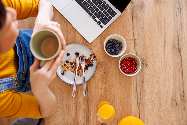 istock Female freelancer finishing up her breakfast while working from home 2233335815