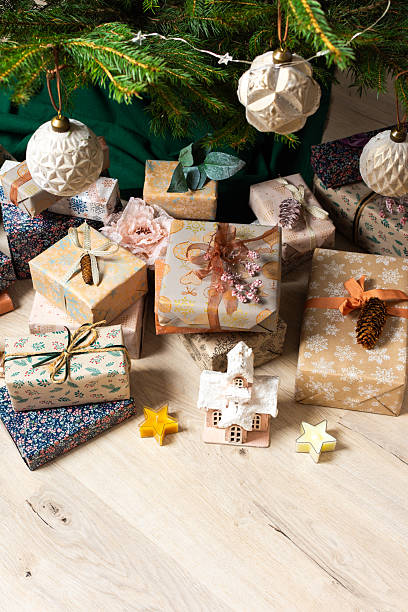 istock A cozy Christmas scene with elegant natural-toned gift boxes placed under a Christmas tree, lit with festive lights, evoking peace and seasonal joy 2233338240