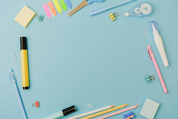 istock Desk with pens, pencils, clips, marker, correction tape, sticky notes, scissors on blue background 2233338372