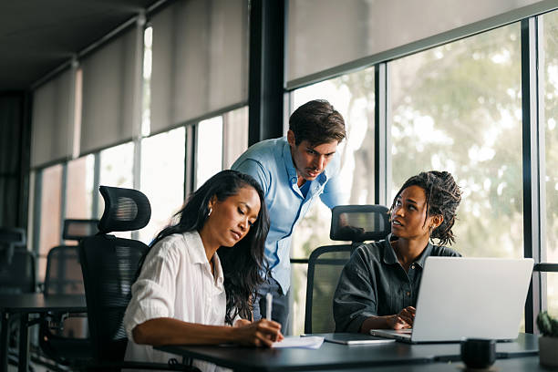istock Busy smiling executive business team using digital devices in office. Diverse professional people 2233341361