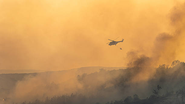 istock Fire fighting helicopter carry water bucket to extinguish the forest fire 2233342704