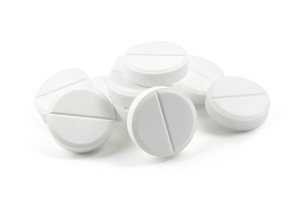 Macro photo of several white pills or dietary supplements arranged on a blue background with spa and wellness decorative elements, soft lighting, and a minimalist composition—ideal for health, medicine, relaxation, or wellness lifestyle concepts.