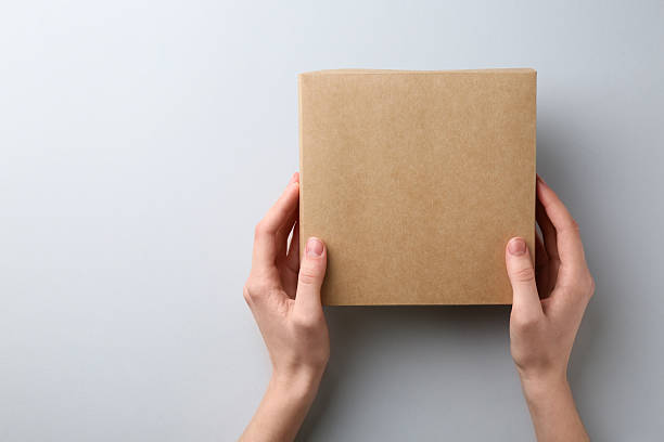 istock Woman with blank cardboard box on white background, top view. Mockup for design 2233344209