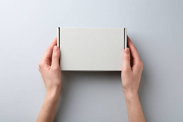 istock Woman with blank cardboard box on white background, top view. Mockup for design 2233344241