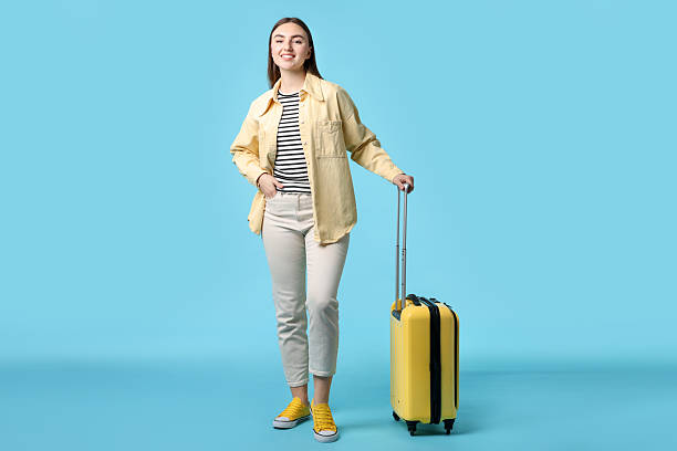 istock Woman with suitcase on light blue background 2233344476