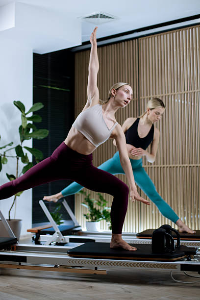 Workout session on reformer pilates machines with focused exercises in a modern studio environment