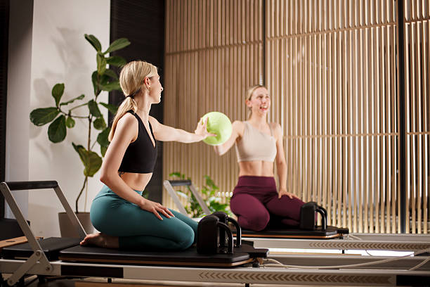 istock Women engaged in reformer pilates workout using equipment in a bright studio environment focusing on fitness and flexibility training 2233346440