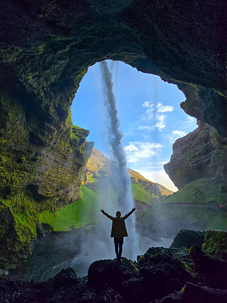 istock Unique perspective of a waterfall cascading through a rocky cave in Iceland under a clear blue sky 2233347288