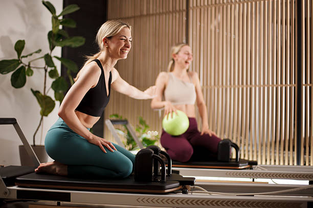 istock Engaging workout session on reformer pilates machines featuring joyful participants in a modern studio setting 2233347307