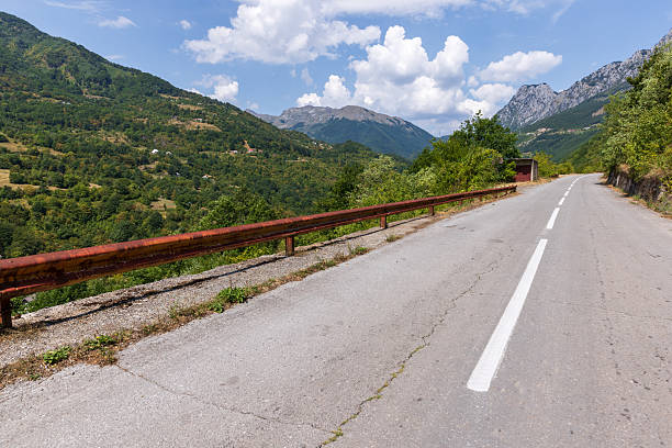 istock A tranquil mountain road with a railing overlooks lush forested hills 2233350795