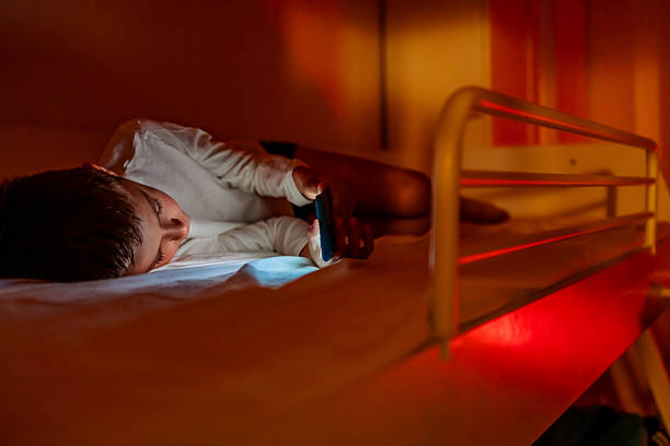 istock Child Using Smartphone in Low Light Room, Evening Ambiance 2233351165