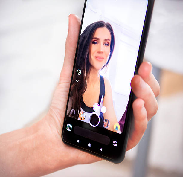 istock Woman using smartphone camera app for selfie with face photo filters at home setting 2233351428
