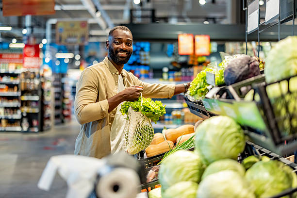 istock Man Shopping for Fresh Vegetables in a Modern Grocery Store 2233353171