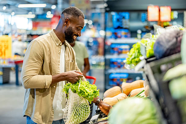istock Smiling Man Shopping for Fresh Vegetables in a Bright Grocery Store 2233353204