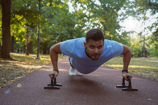 istock Outdoor Calisthenics Workout Using Push-Up Bars in the Park 2233353598