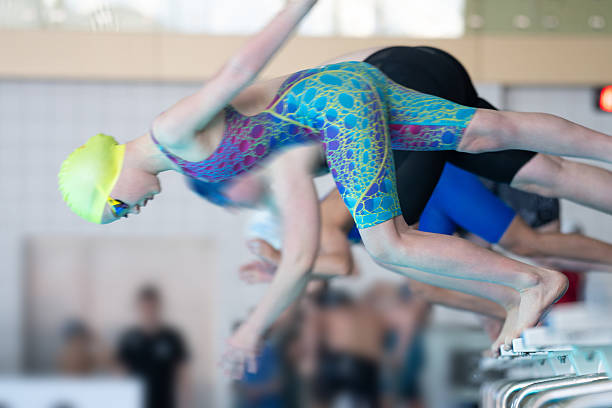 istock Swimmer girl start from the starting table in the pool 2233355584