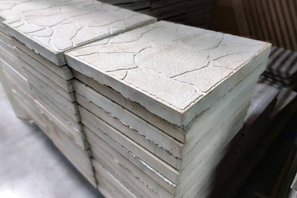 istock Stacked concrete tiles with textured surfaces arranged neatly in a construction facility during daylight hours 2233358503
