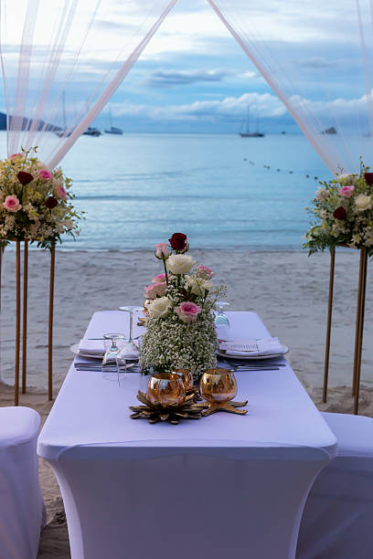 istock Elegant beachside dining setup with floral arrangements and serene ocean backdrop for special occasions 2233361562