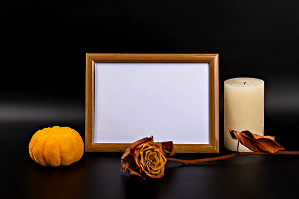 istock Decorative autumn arrangement with pumpkin, dried rose, candle and empty frame for Halloween theme 2233361578