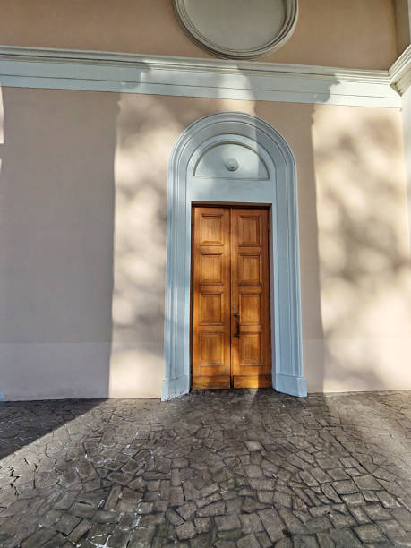 istock A closed wooden door in a neoclassical frame, casting soft shadows on a textured floor. The image evokes themes of mystery, introspection, and the barriers we face in our minds 2233362756
