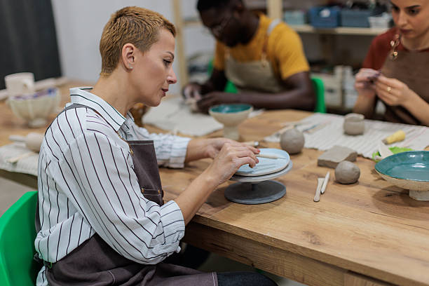 istock Woman decorating clay plate 2233362956