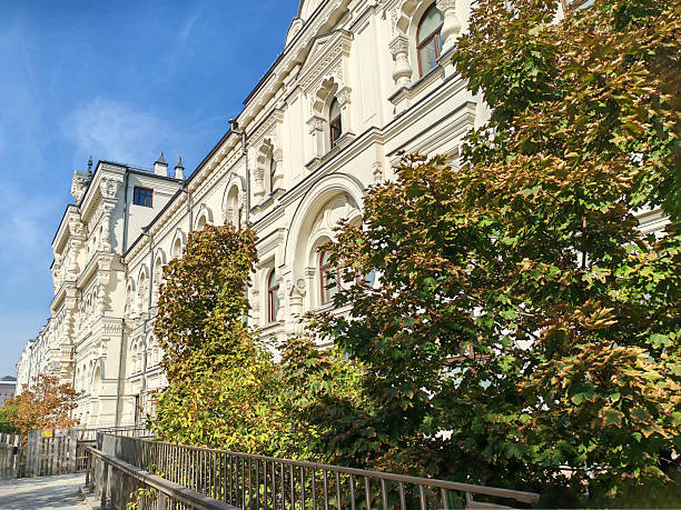 A neoclassical building with ornate arched windows and intricate detailing, surrounded by temporary fencing. The scene captures ongoing restoration efforts to preserve its architectural heritage.