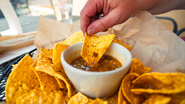 Close-Up of Tortilla Chip Being Dipped into Salsa