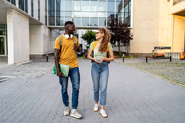 istock Cheerful university students walking and talking outdoors 2233363737