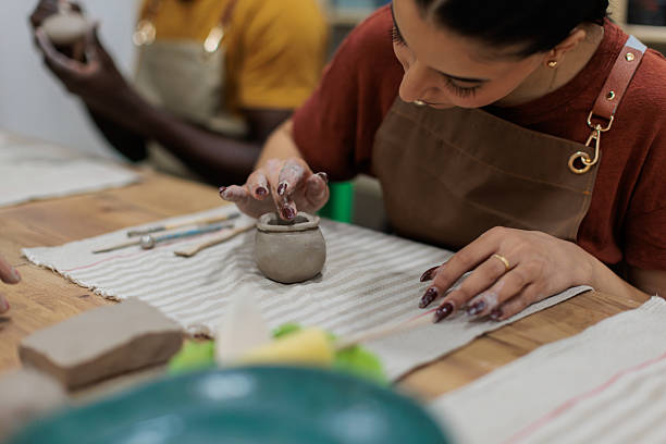 istock Focused woman sculpting clay jar 2233365486