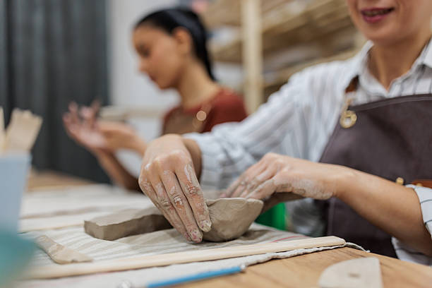istock Woman molding clay in pottery class 2233365974
