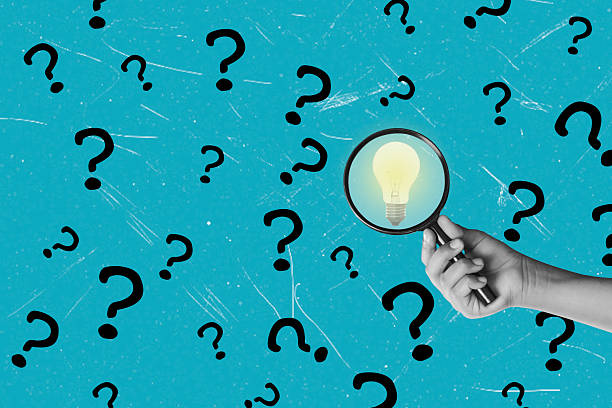 istock Art collage. A hand holds a magnifying glass that focuses on a light bulb, symbolizing the search for ideas and answers. 2233367420