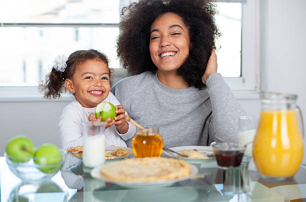 istock African-American young mother and daughter having breakfast 2233367752