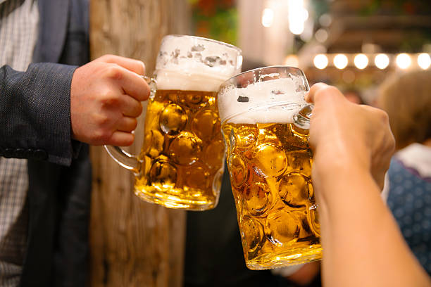 istock Two Beer Mugs Clinking at a Festive Beer Fest Celebration 2233368820
