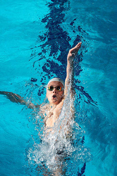 istock Swimmer boy swims backstroke swimming style in the pool 2233372781