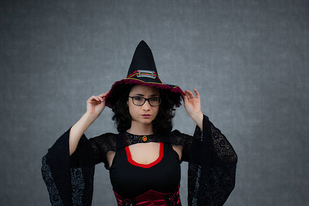 Little girl with witches hat hiding in the woods. Note for inspection; hat is not branded by any company, random hat.
