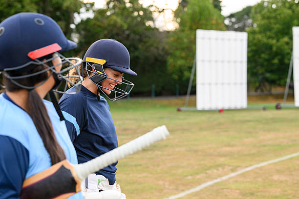 istock Side view women's batting pair walking on to field together 2233374343
