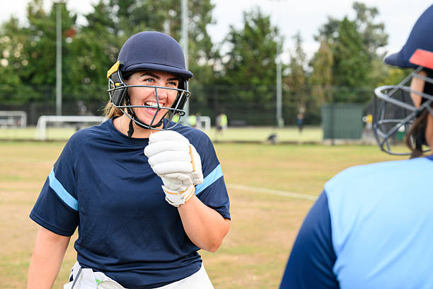 istock Female batsman laughing with team mate on field 2233374441