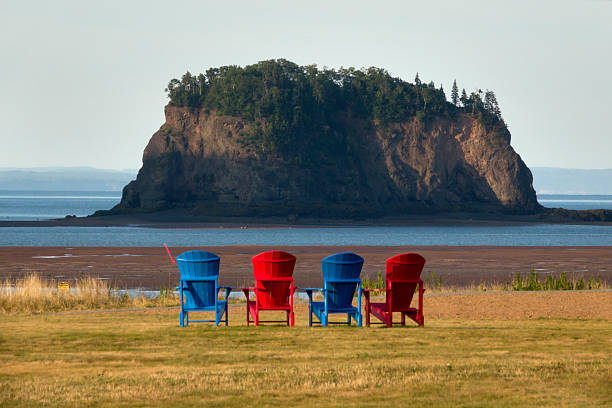 Colorful reclining Adirondack chairs at stand at the high point overlooking the sea stacks of Five Island Provincial Park, Nova Scotia, Canada.
