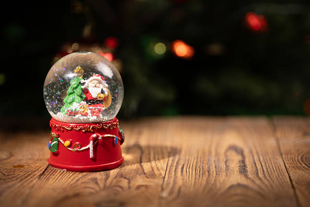 istock Snow Globe Featuring a Festive Christmas Theme With a Tree and Decorations on a Wooden Surface 2233375966
